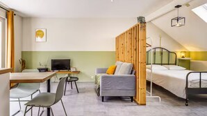 A modern room with a bed, a sofa, a desk, and a TV. - Studio with terrace between Liège and Maastricht (Juprelle)