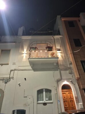 Un edificio con un balcone, una porta e una finestra.