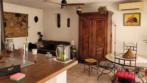 Una sala de estar con una mesa de madera, un sofá, un ventilador de techo y un aparador.