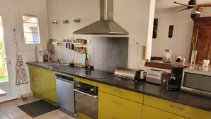 Una cocina con lavavajillas, horno y cafetera en la encimera.