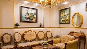 A room with ornate furniture, a chandelier, and maritime-themed paintings. - Luna Hotel & Terrace (Baku)