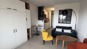 Uma sala de estar moderna com sofá, cadeiras e uma área de jantar.