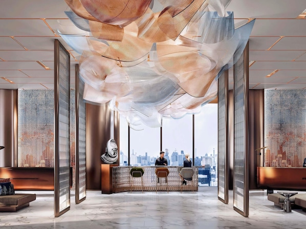 A spacious lobby with a reception desk, seating area, and large windows offering a city view. - Ibis Bangkok Siam Ratchathewi (Bangkok)