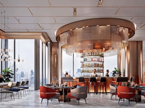 A modern bar area with a circular chandelier, a wine rack, and seating arrangements. - Ibis Bangkok Siam Ratchathewi (Bangkok)