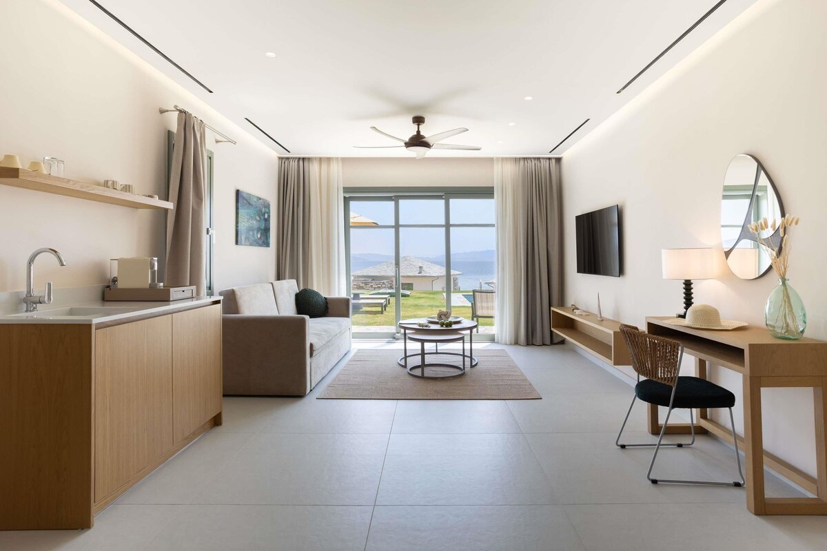 Ein modernes Hotelzimmer mit einer Küche, einer Sitzecke und einem großen Fenster mit Blick.