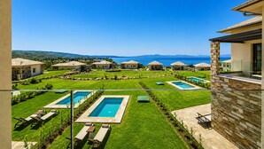 Ein Wohngebiet mit mehreren Häusern, einem Swimmingpool und Blick aufs Meer.