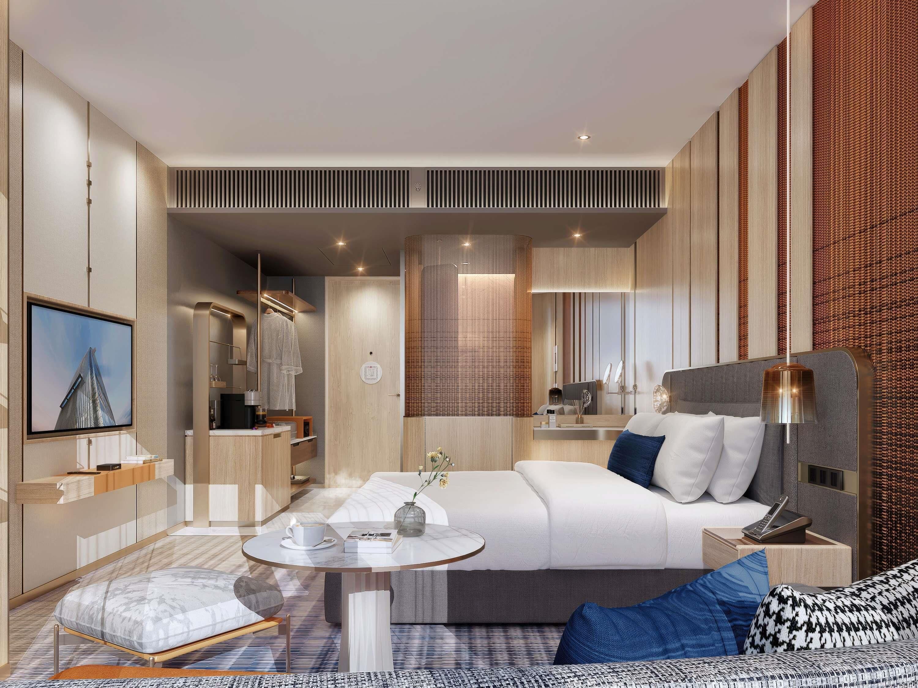 A modern hotel room with a bed, bedside table, lamp, and a TV mounted on the wall.