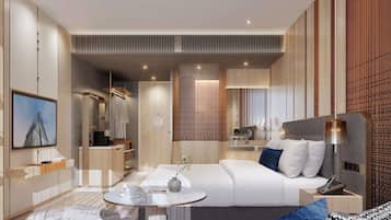 Quarto de hotel moderno com cama, mesa de cabeceira, luminária e televisão fixada na parede.