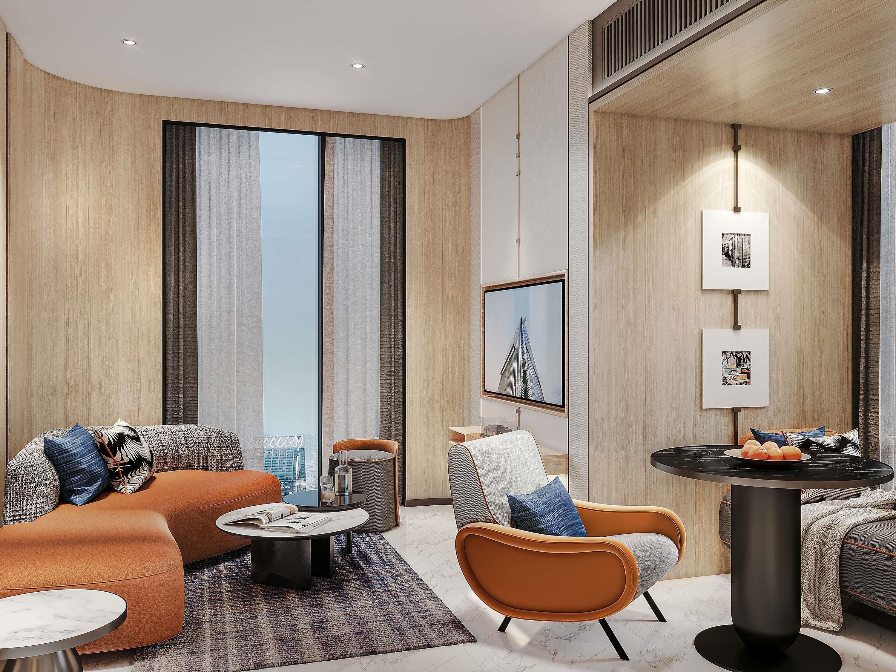 A modern hotel room with a sofa, armchair, coffee table, and a small dining table.