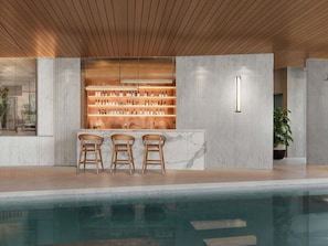 A bar area with a marble countertop, wooden chairs, and shelves of bottles. - Mercure Bangkok Siam Ratchathewi (Bangkok)