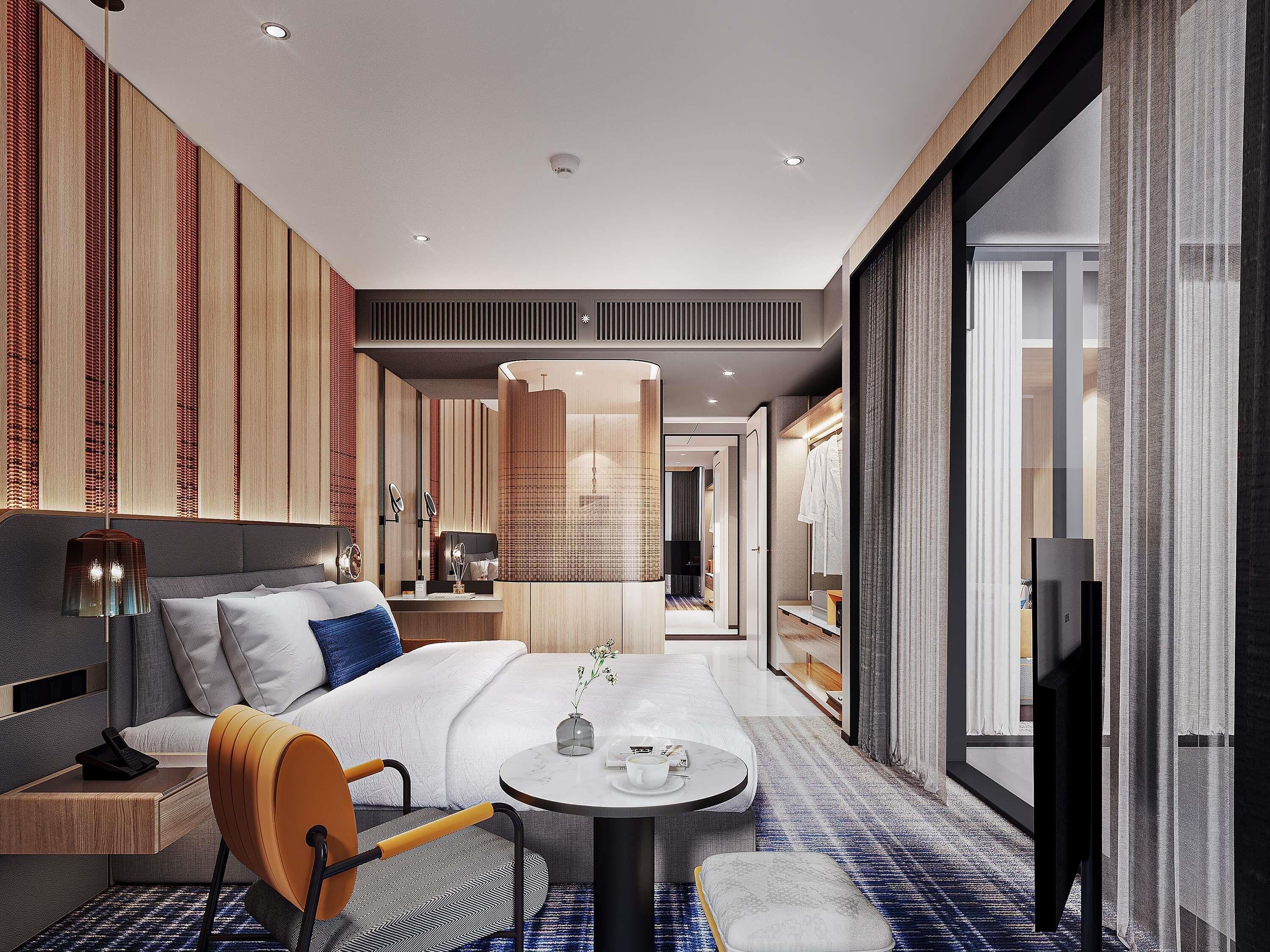 A modern hotel room with a bed, a small table, a chair, and a television.
