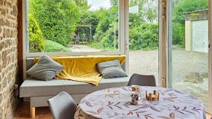 Ein gemütliches Zimmer mit einer Couch, einem Tisch und Blick auf einen Garten.