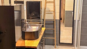 Een moderne keuken met een roestvrijstalen koelkast, een houten aanrechtblad en een inbouwoven.