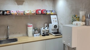 A compact kitchen with a sink, a coffee machine, and a water dispenser. - Danbam Hotel (Cheongju)
