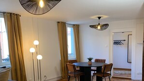 Ein Essbereich mit Holztisch, Stühlen und Pendelleuchten.