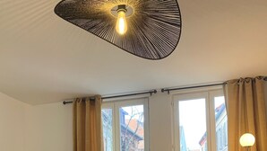 Ein Wohnzimmer mit einer Couch, einem Couchtisch, einer Stehlampe und einem Fenster mit Vorhängen.