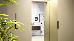 Ein Flur im modernen Stil, mit einem an der Wand befestigten Schrank mit Schubladen und einem gerahmten Schild.