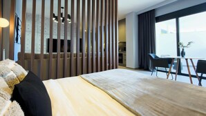 Ein modernes Hotelzimmer mit einem großen Bett, einem Schreibtisch und Blick auf die Stadt.