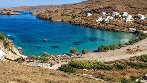 Un pueblo costero con edificios blancos, mar azul cristalino y colinas en terrazas.