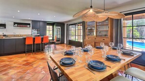A modern dining area with a wooden table set for six, surrounded by orange chairs. - L'écrin d'été - Nature & Calm (Ventabren)