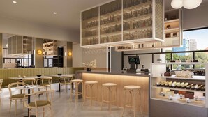 Ein modernes Restaurantambiente mit Bar, Holzsesseln und einer Auswahl an Desserts.
