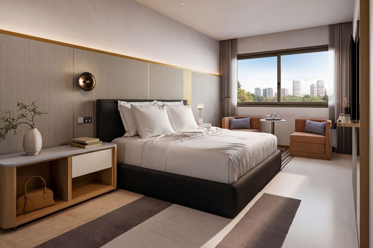 Una habitación de hotel moderna con una cama grande, mesitas de noche, un pequeño sofá, una mesita auxiliar y una ventana con vistas a la ciudad.