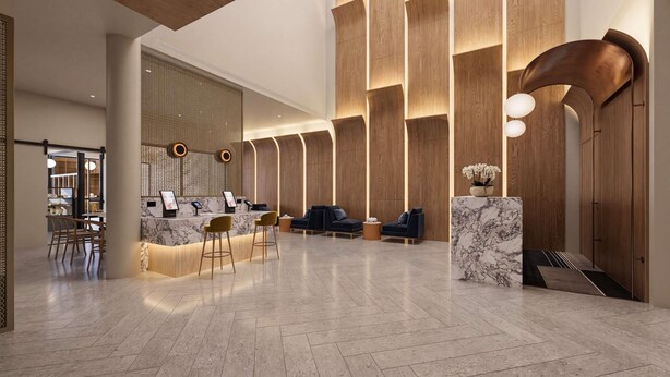 Eine großzügige Lobby mit Empfangstresen, einer Sitzecke und einer Wand mit integrierter Beleuchtung.