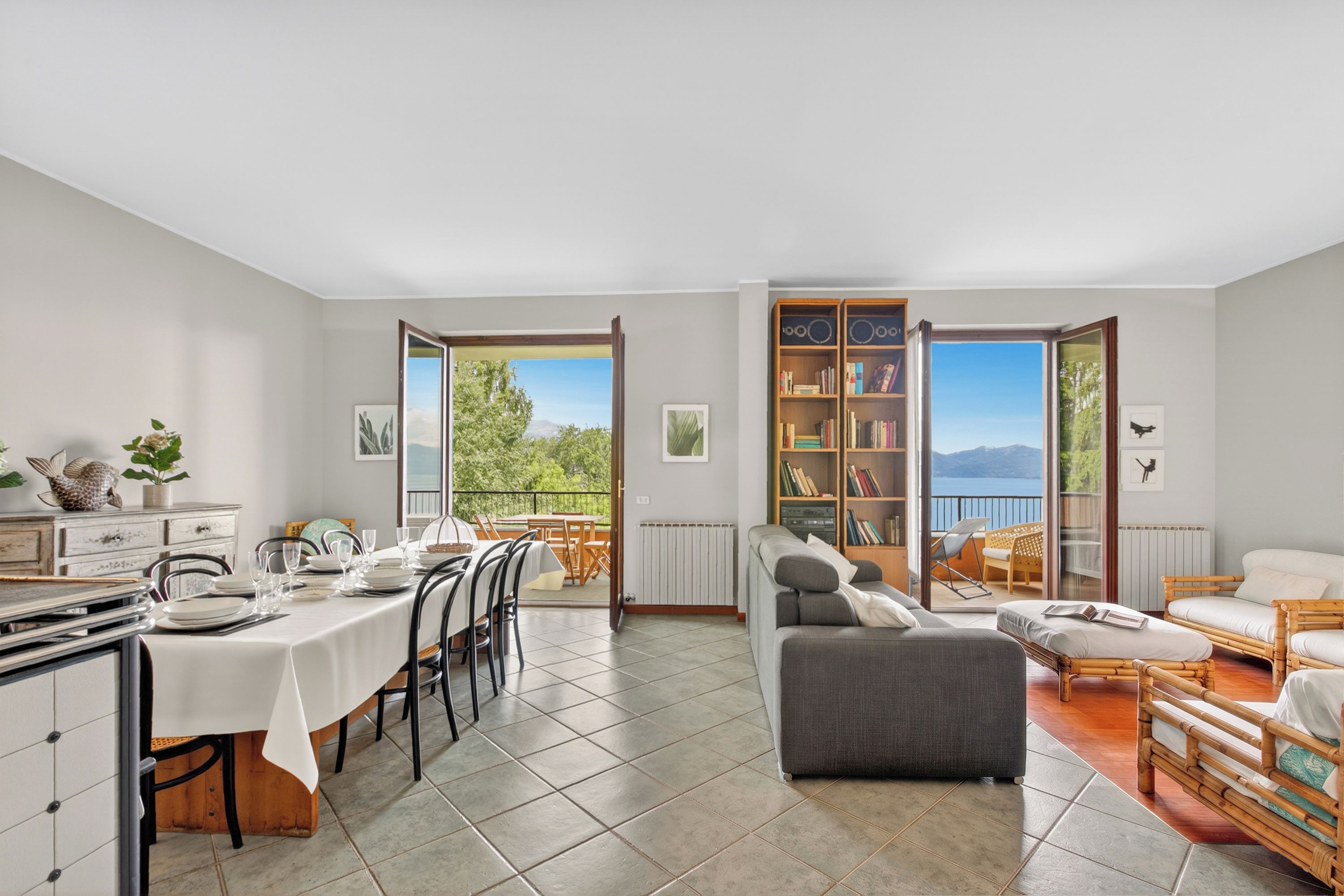 Amplia sala de estar con una mesa de comedor, sofás y una estantería.