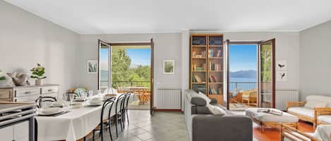Amplia sala de estar con una mesa de comedor, sofás y una estantería.