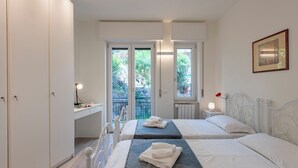 Ein Schlafzimmer mit zwei Betten, einem Schreibtisch und Blick ins Grüne.