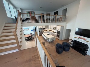 A spacious living area with a staircase, a kitchen, and a dining area. - Newly constructed home in The Peninsula - 23708 Brickwalk ~ (Millsboro)