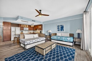 A compact hotel room with a kitchenette, two beds, a ceiling fan, and a large window. - Laketown Wharf 413 | Resort Pools, Walk to Beach, Sleeps 8 (Panama City Beach)