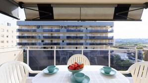 A balcony with a table, chairs, and a bowl of fruit. - Family Apartments 2 Nova Pineda (La Pineda)