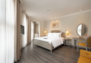 A hotel room with a bed, bedside tables, a chair, a mirror, and a television. - Tranquil Stay – Boutique 4-Star Experience in Sa Pa (Sa Pa)