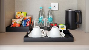 Ein Frühstückswagen im Hotelzimmer mit Tassen, einer Kaffeemaschine und verschiedenen Speisen.