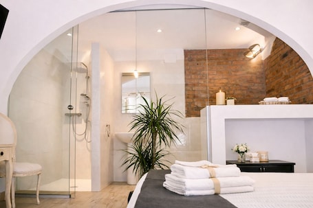 A modern bathroom with a glass-enclosed shower, a sink, and a mirror.. Locanda Divinis