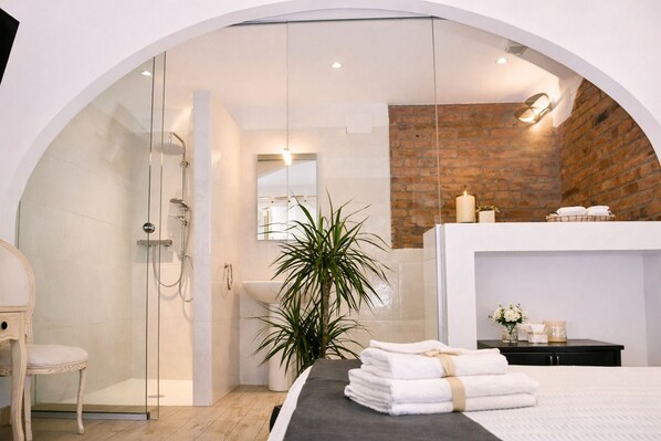 A modern bathroom with a glass-enclosed shower, a sink, and a mirror.