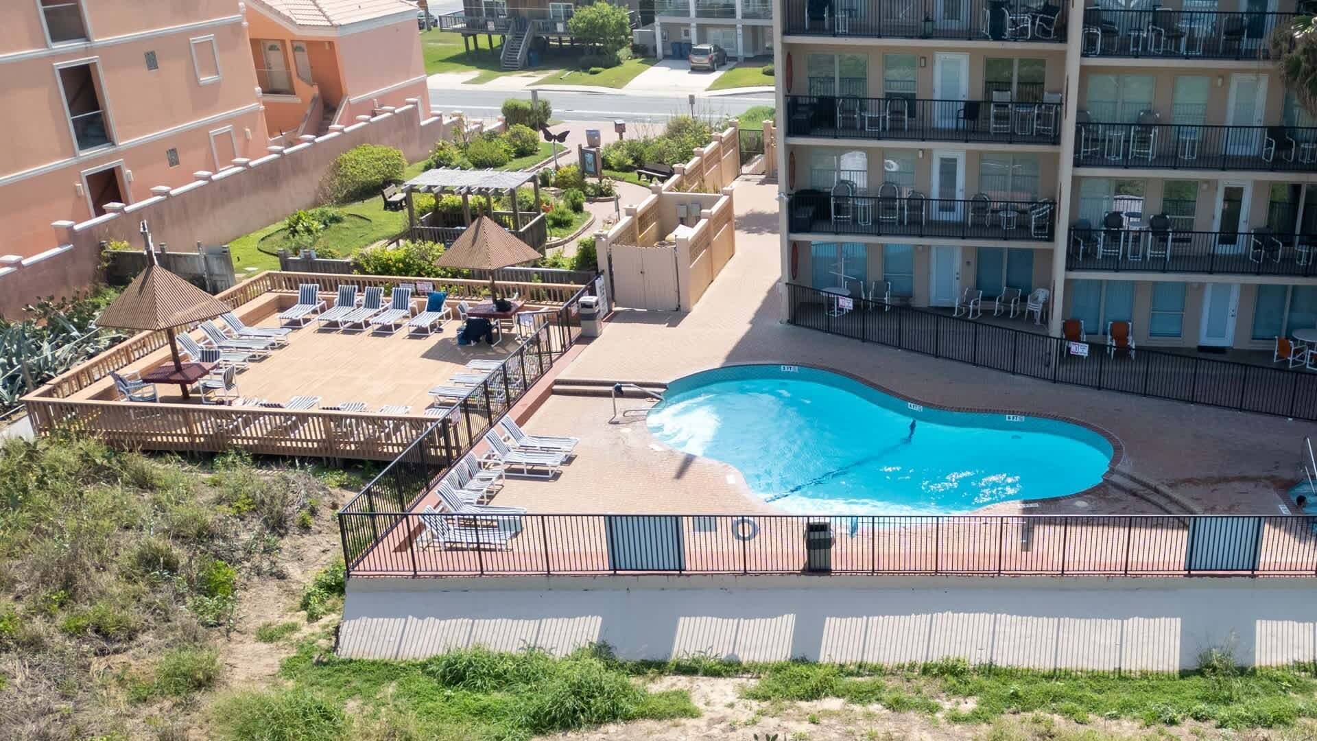 En pool på taget med liggestole og en træterrasse.