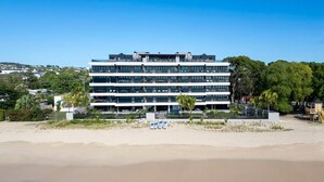 Un hotel a più piani con vista spiaggia, situato su una spiaggia sabbiosa.