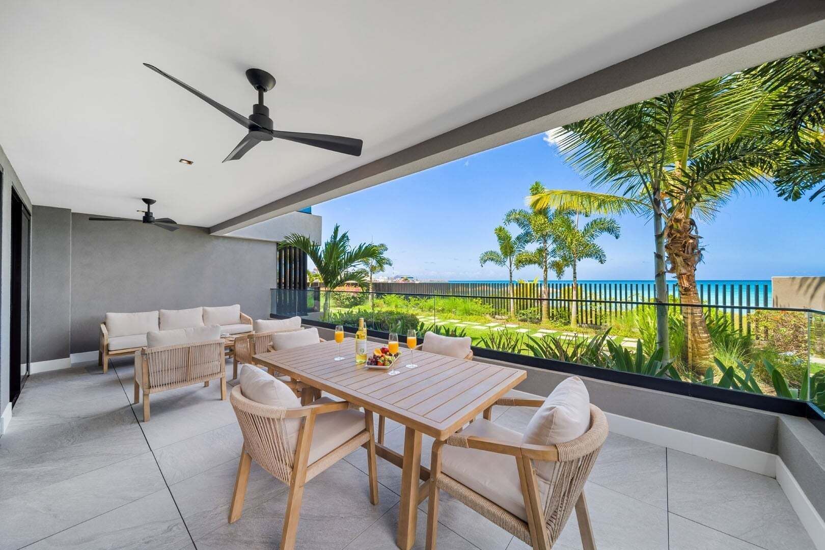 Une terrasse ext érieure moderne, dotée d’une table à manger, de chaises et d’un ventilateur de plafond.