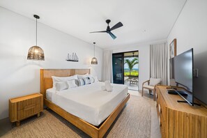 A modern hotel room with a large bed, a ceiling fan, a TV, and a balcony with a view. - Allure 105 3 Bedroom Condo (Bridgetown)