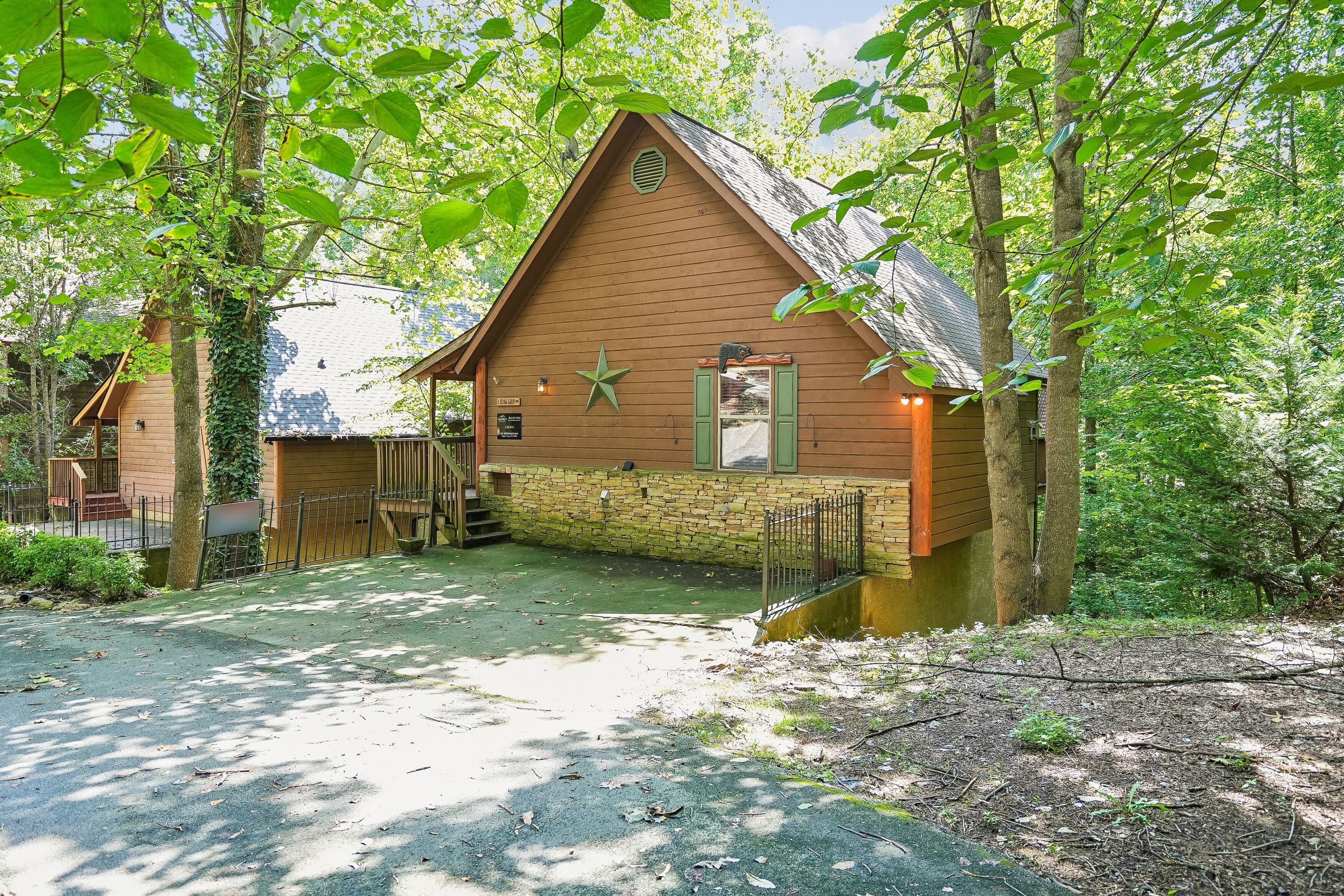A rustic cabin with a stone foundation, a wooden roof, and a star decoration on the wall.