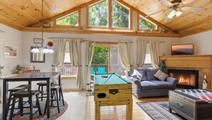A cozy room with a wooden ceiling, a pool table, a sofa, a fireplace, and a dining table with chairs. - 3 Bears Cabin 1 Bedroom Cabin (Pigeon Forge)