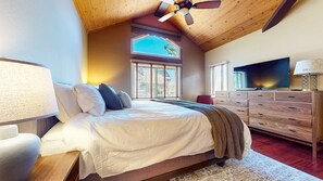 A bedroom with a bed, a TV, a dresser, and a window with a view. - The Pointe #02 3 Bedroom Townhouse (Mammoth Lakes)