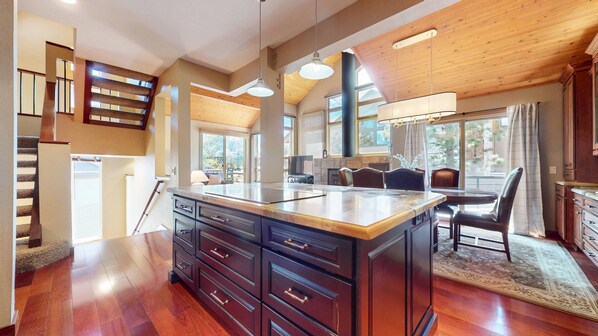 A spacious kitchen with a large island, wooden flooring, and a view of the outdoors. - The Pointe #02 3 Bedroom Townhouse (Mammoth Lakes)
