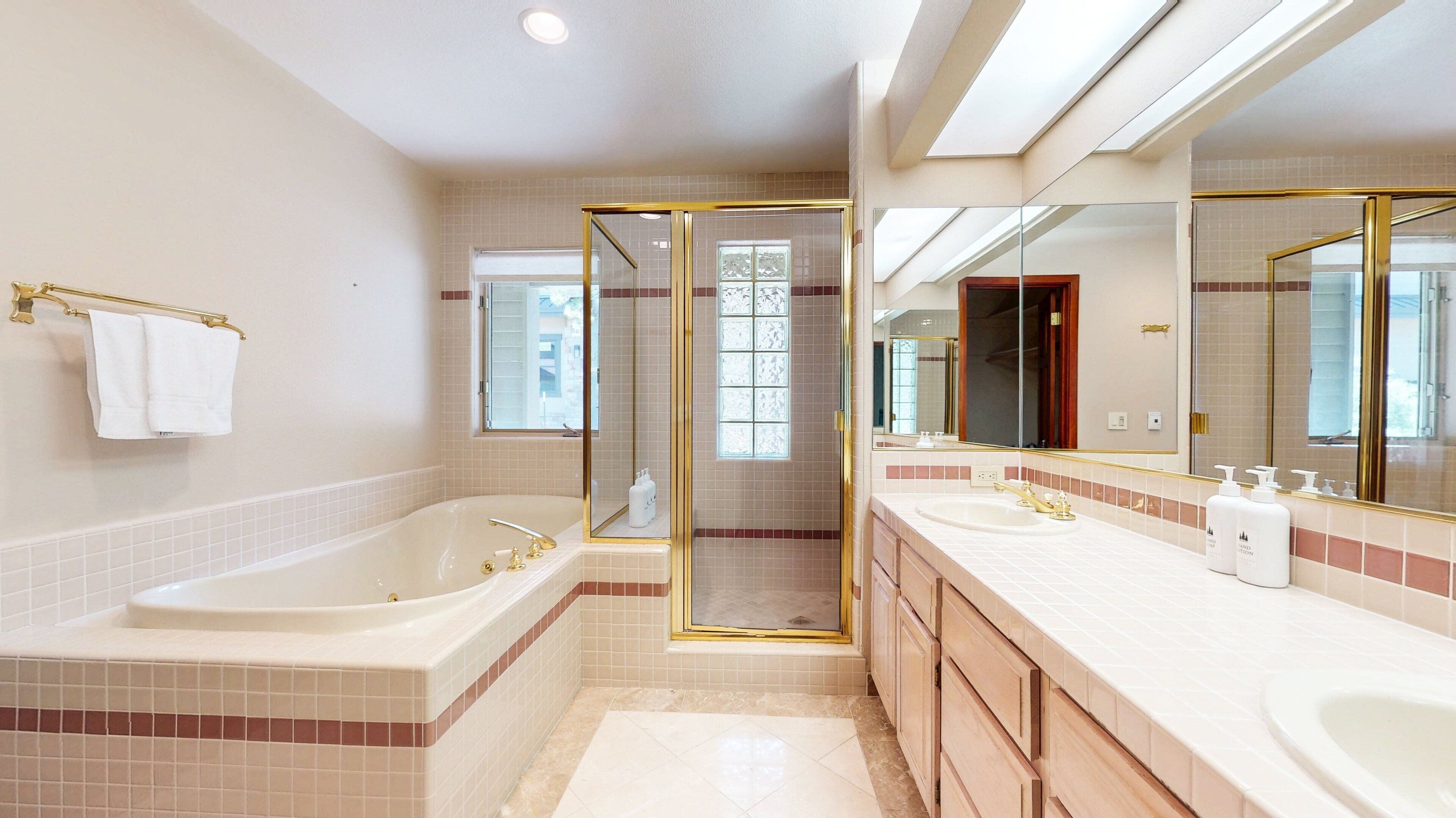 Une salle de bain moderne dotée d’une grande baignoire, de deux lavabos et d’une douche à l’italienne.