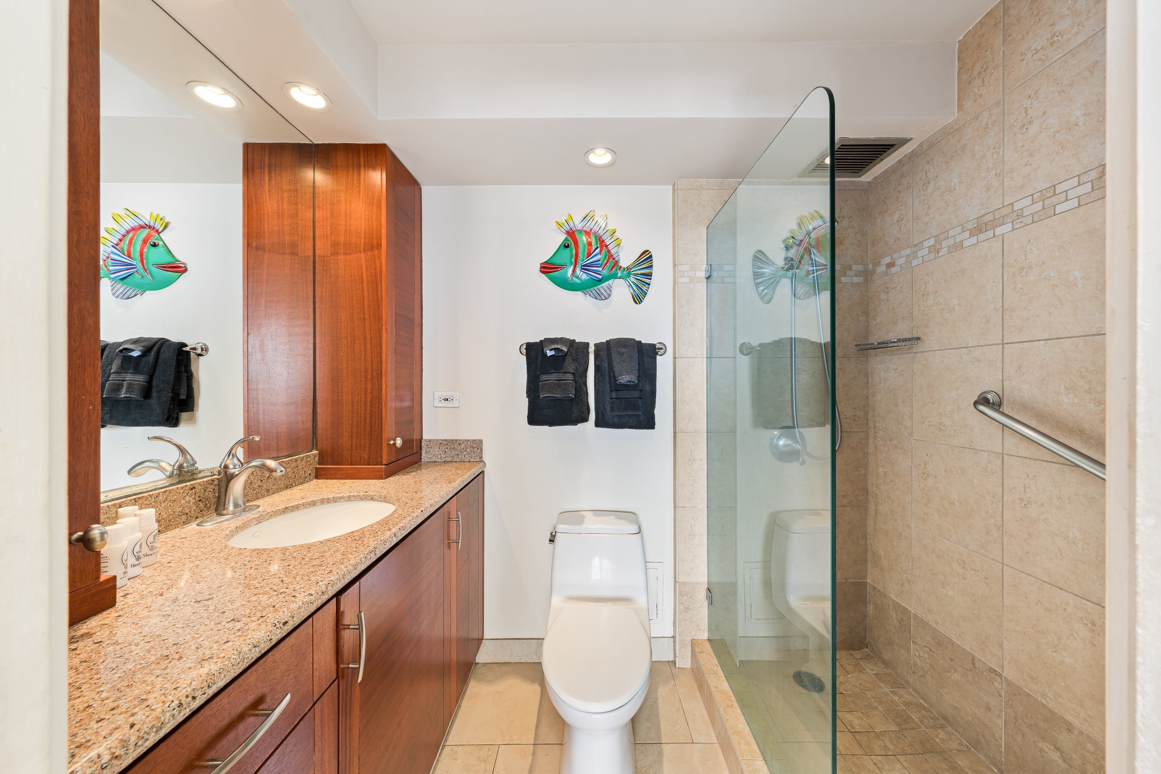 A bathroom with a sink, toilet, and shower.