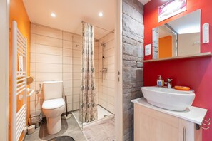 Une salle de bain avec des toilettes, une douche et un lavabo.