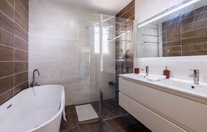 A modern bathroom with a glass-enclosed shower, a freestanding bathtub, and a vanity with a mirror. - Villa du Clos de l'Olivier avec piscine à Tourrettes (Tourretes sur Loup)