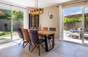 A dining area with a wooden table, chairs, and a chandelier. - Villa du Clos de l'Olivier avec piscine à Tourrettes (Tourretes sur Loup)